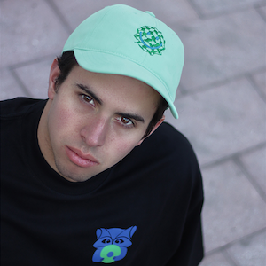 hombre gorra verde camisa negra mapache dj